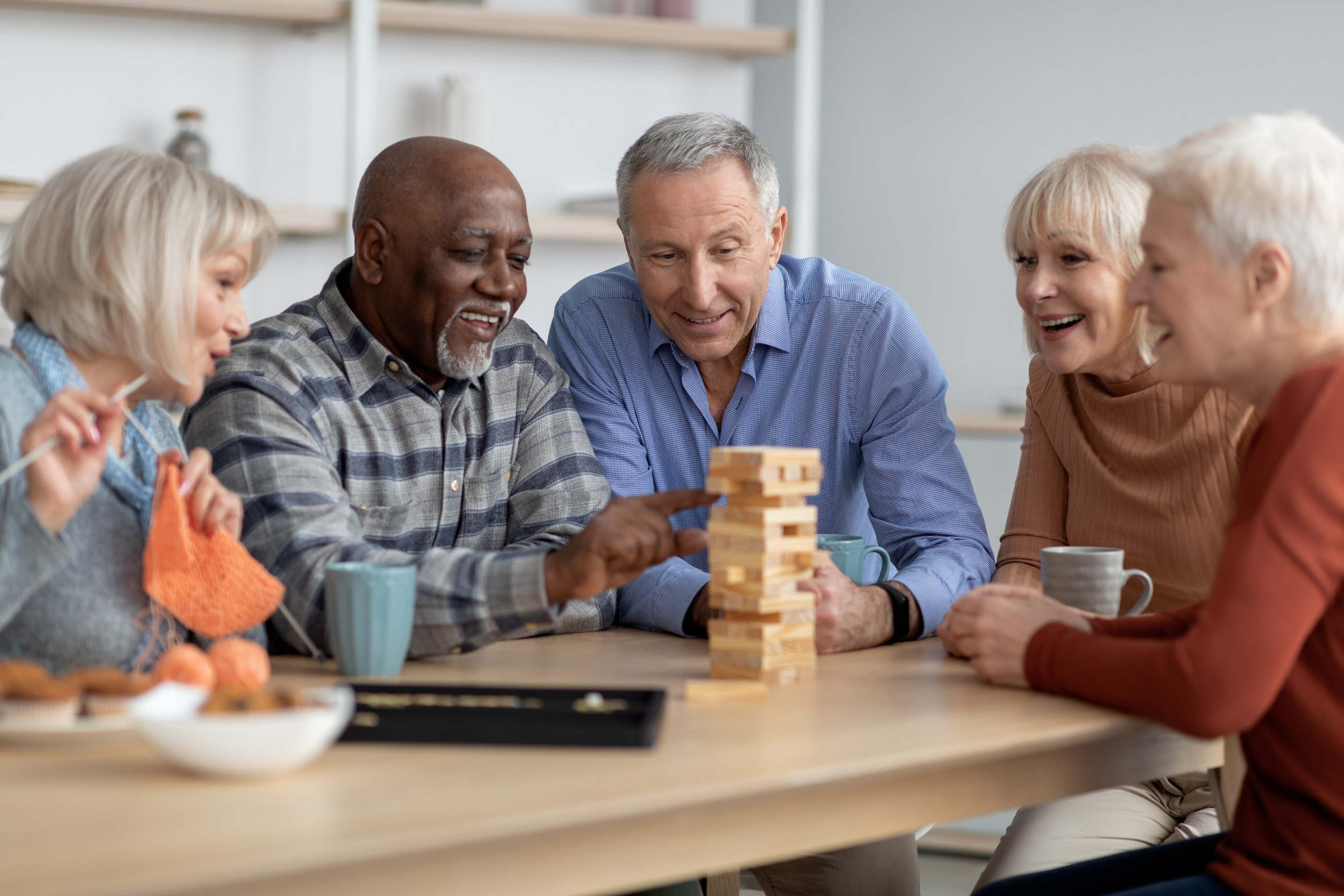 Emotional seniors playing jenga, having fun at sanatorium
